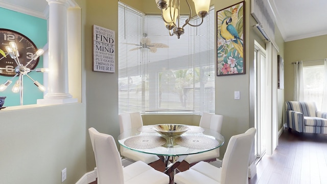 dining area with a notable chandelier, crown molding, hardwood / wood-style floors, and decorative columns