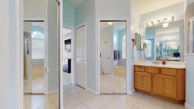 bathroom with vanity, vaulted ceiling, and tile patterned floors