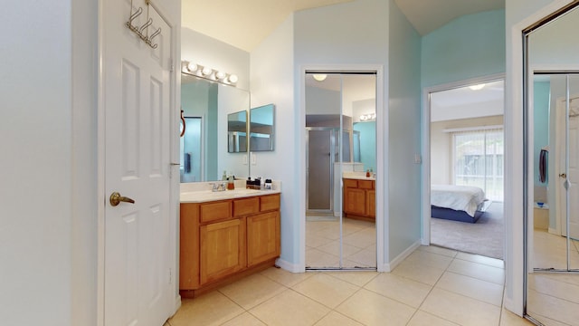 bathroom featuring tile patterned flooring, an enclosed shower, and vanity