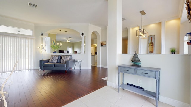 living room featuring ceiling fan, light wood-type flooring, and ornamental molding