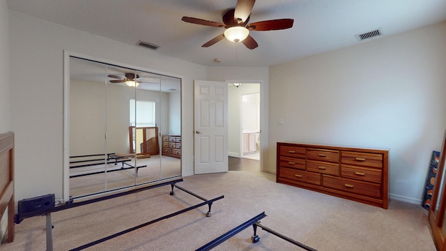 exercise area with ceiling fan and light colored carpet