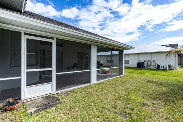 view of yard featuring a sunroom and central AC unit