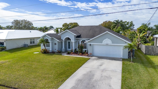 ranch-style house with a garage, cooling unit, and a front lawn