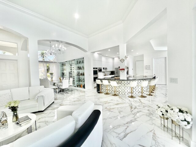 living room featuring a chandelier, ornamental molding, and a high ceiling