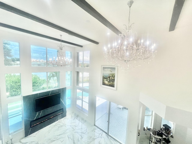 living room featuring beamed ceiling and an inviting chandelier