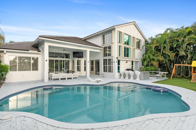 rear view of property with a playground, ceiling fan, and a patio area