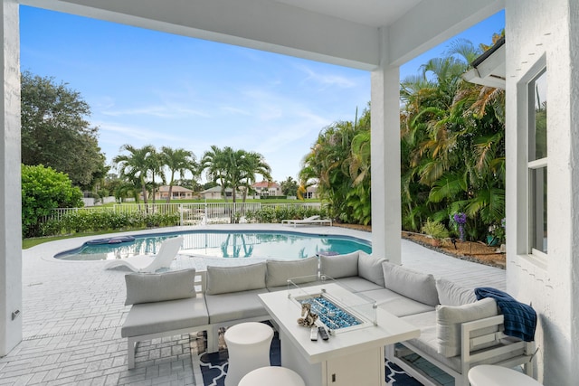 view of pool with a patio area and an outdoor living space with a fire pit