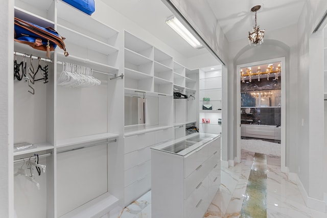 spacious closet with a chandelier