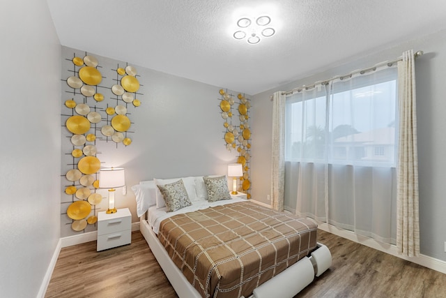 bedroom featuring a textured ceiling and hardwood / wood-style flooring