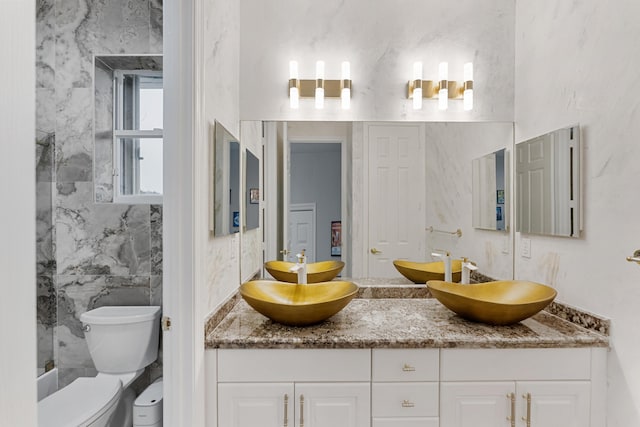 bathroom with tile walls, toilet, and vanity