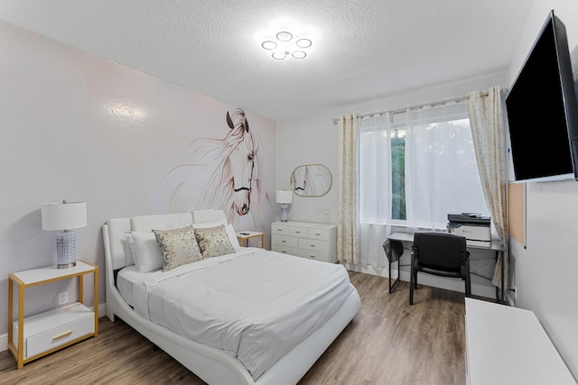 bedroom with a textured ceiling and wood-type flooring