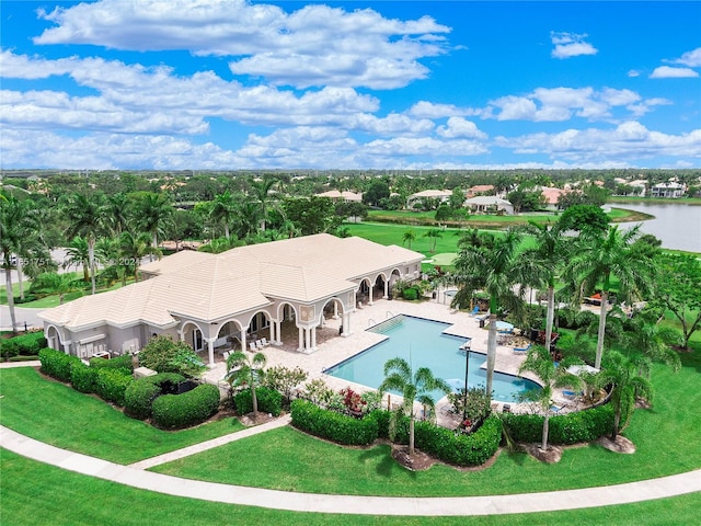 view of swimming pool featuring a lawn, a water view, and a patio