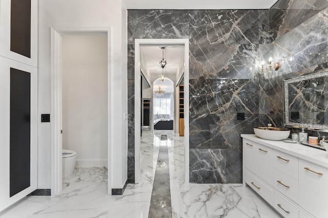 bathroom featuring toilet, tile walls, and vanity