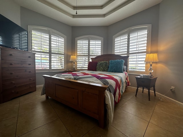 tiled bedroom with a raised ceiling and multiple windows