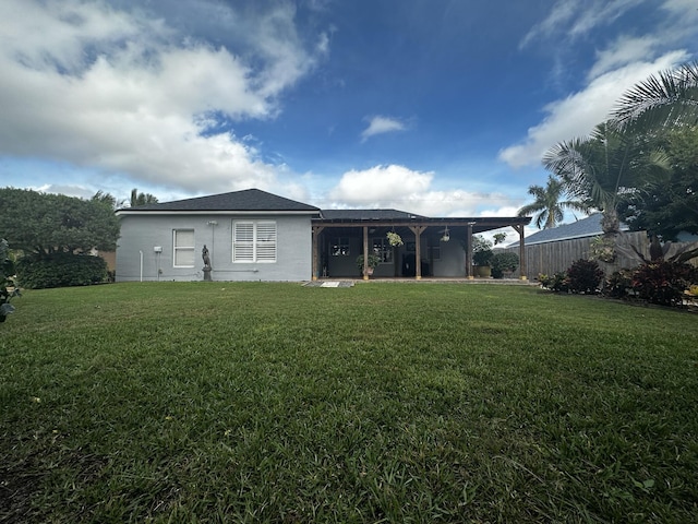 rear view of property featuring a lawn