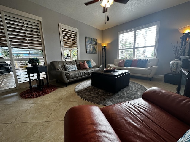 living room featuring a textured ceiling, ceiling fan, and light tile patterned floors