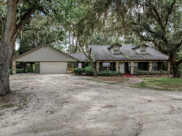 view of front of property with dirt driveway, stone siding, and a garage