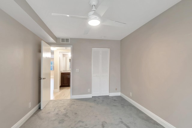 unfurnished bedroom with ceiling fan, a closet, and light colored carpet