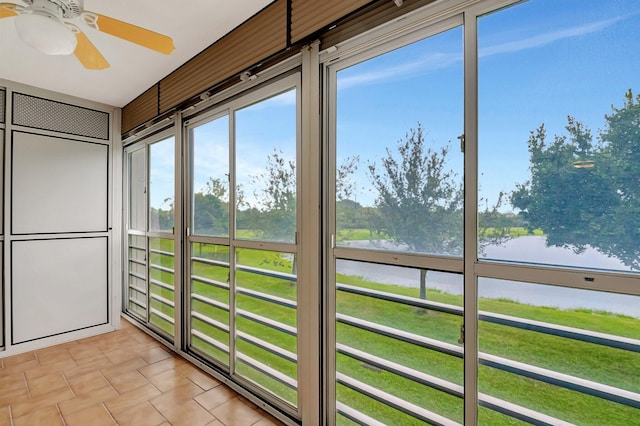 unfurnished sunroom featuring a water view and ceiling fan