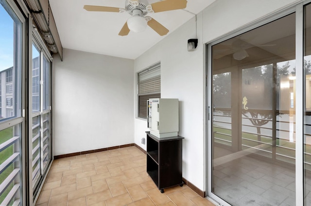 unfurnished sunroom with ceiling fan