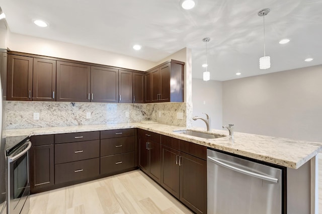 kitchen featuring pendant lighting, stainless steel appliances, tasteful backsplash, sink, and kitchen peninsula