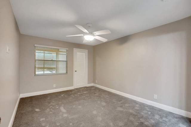 carpeted spare room featuring ceiling fan