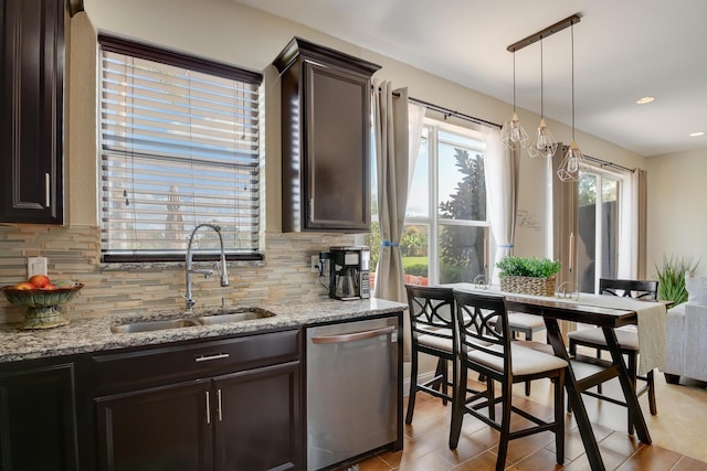 kitchen featuring decorative light fixtures, decorative backsplash, stainless steel dishwasher, and sink