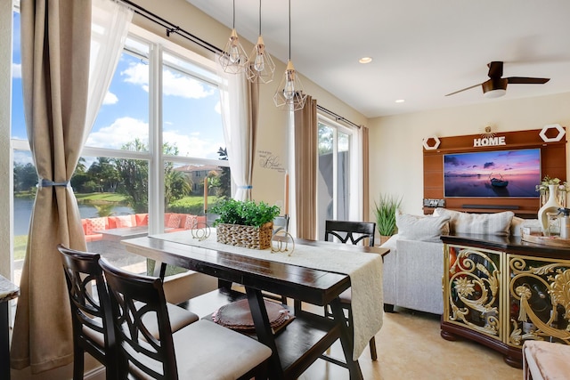 dining area featuring ceiling fan and a water view