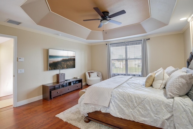 bedroom featuring wood-type flooring, ceiling fan, crown molding, and a raised ceiling