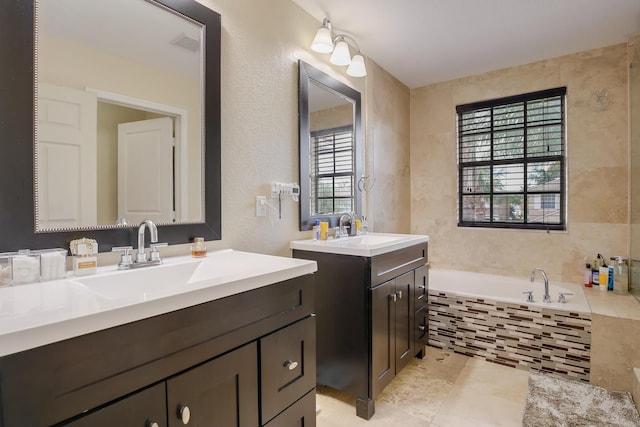 bathroom with vanity, tile patterned floors, and tiled tub