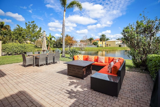 view of patio featuring an outdoor living space with a fire pit and a water view