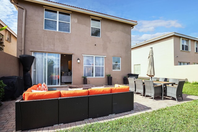 rear view of house with outdoor lounge area and a patio