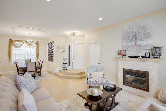 living room with light tile patterned floors, a chandelier, crown molding, and a stone fireplace