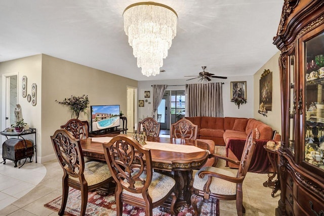 tiled dining space featuring ceiling fan with notable chandelier