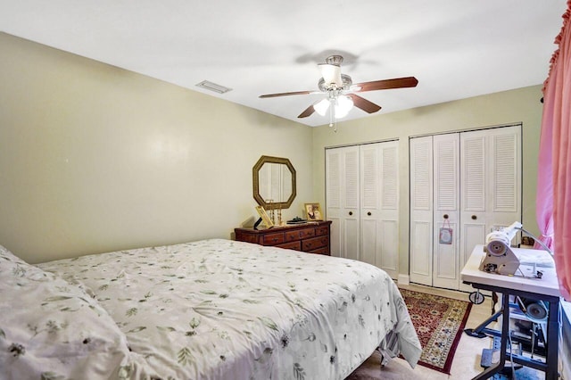 bedroom featuring ceiling fan and multiple closets