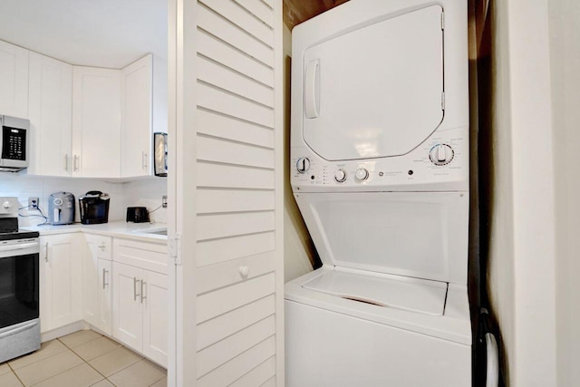 washroom with light tile patterned flooring, stacked washer / drying machine, and wooden walls