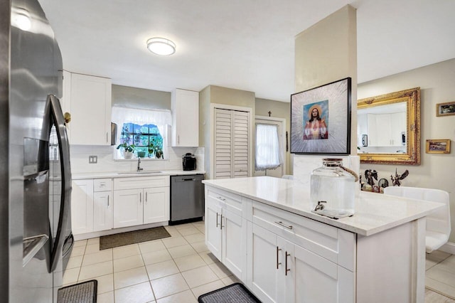 kitchen featuring a wealth of natural light, sink, stainless steel appliances, and white cabinetry