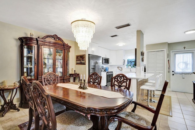 dining room featuring light tile patterned floors and a chandelier