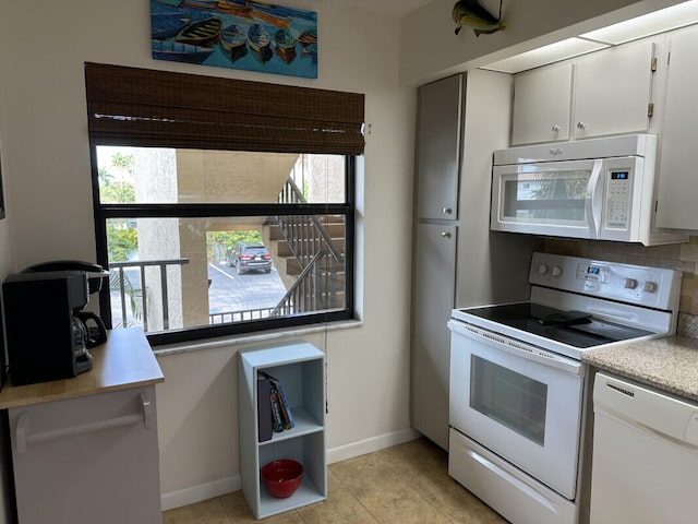 kitchen featuring white cabinets, plenty of natural light, and white appliances