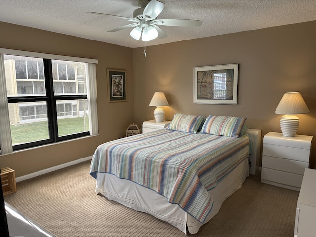 carpeted bedroom with ceiling fan and a textured ceiling