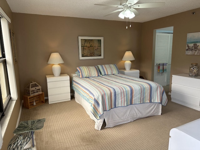 carpeted bedroom featuring a textured ceiling, ceiling fan, and a closet