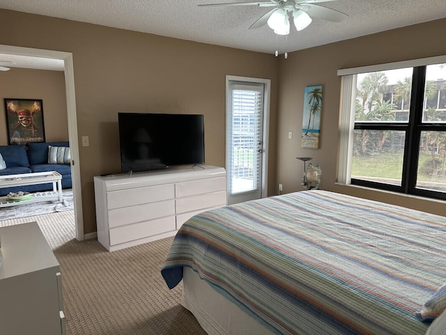 bedroom with ceiling fan, light carpet, and a textured ceiling