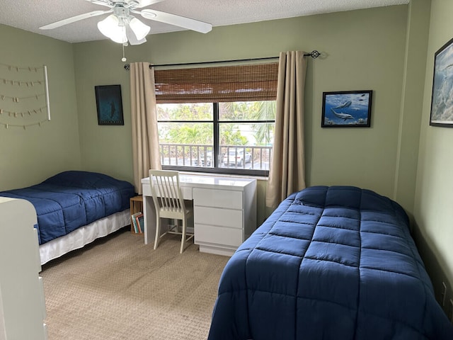 bedroom featuring ceiling fan, a textured ceiling, and light carpet