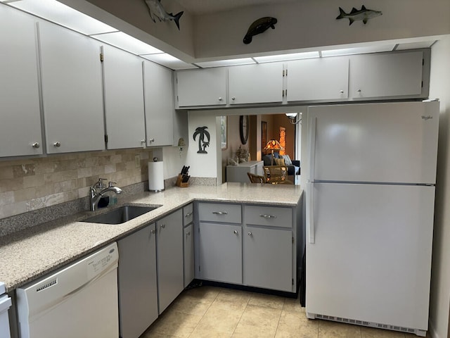 kitchen with decorative backsplash, sink, white appliances, light tile patterned flooring, and gray cabinetry