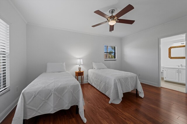 bedroom with ceiling fan, dark wood-type flooring, ornamental molding, a walk in closet, and a closet