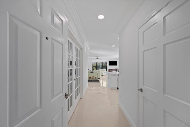 corridor featuring light tile patterned floors and ornamental molding