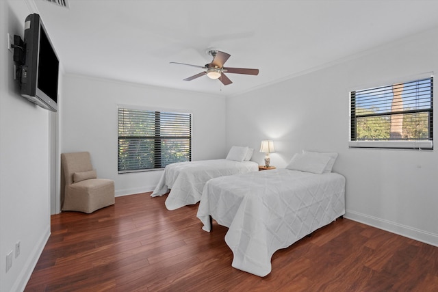 bedroom with crown molding, ceiling fan, and dark hardwood / wood-style floors