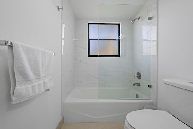 bathroom featuring tiled shower / bath, tile patterned floors, and toilet