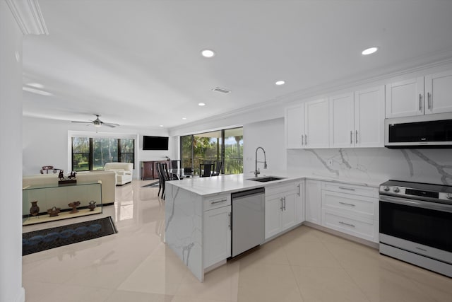 kitchen with ceiling fan, kitchen peninsula, sink, stainless steel appliances, and white cabinets