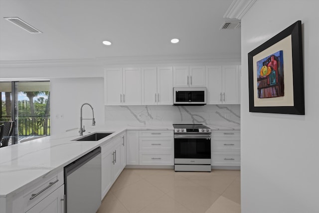 kitchen with white cabinets, stainless steel appliances, sink, backsplash, and kitchen peninsula